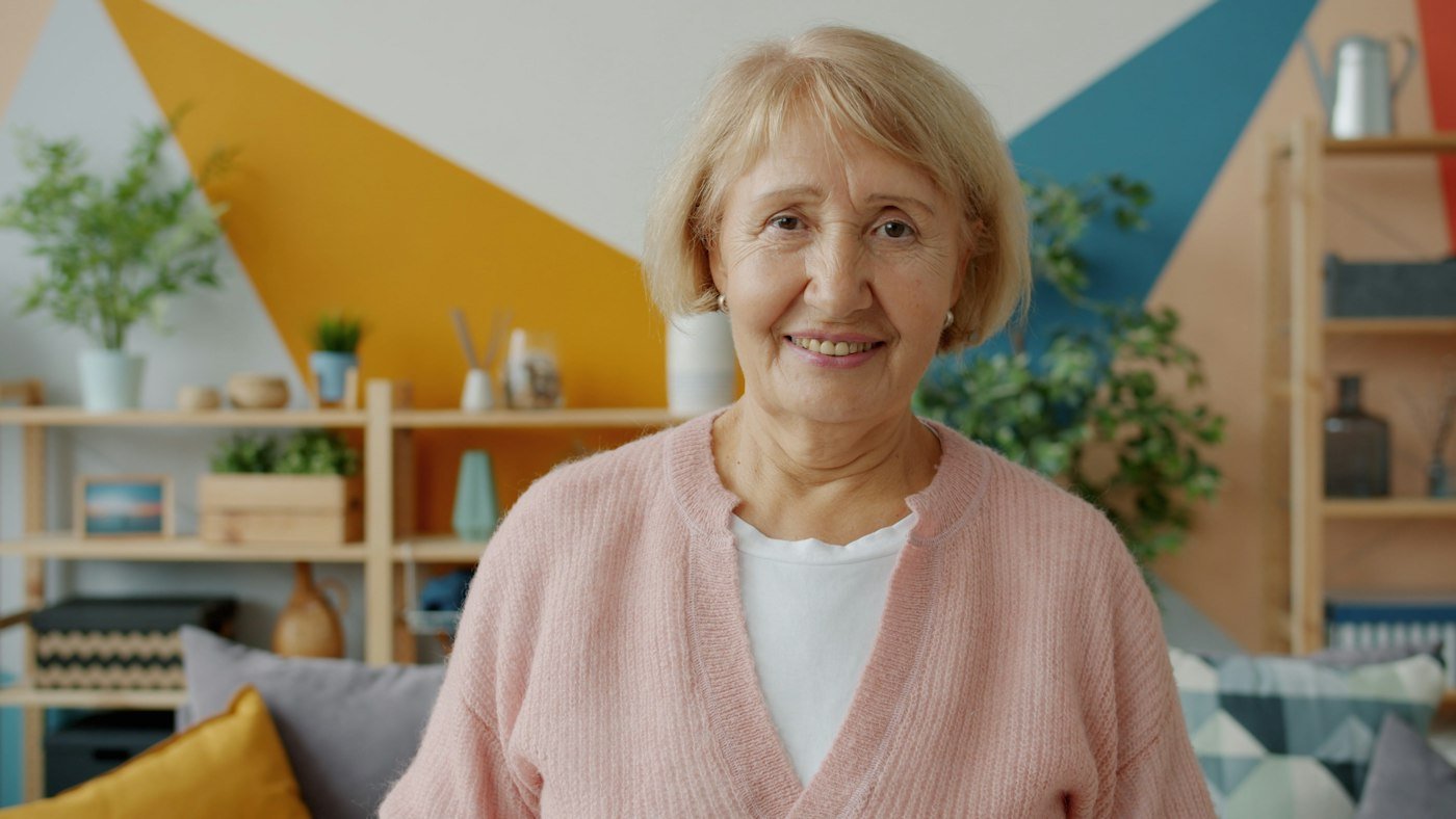 Idosa sorridente em casa, com tranquilidade e independência